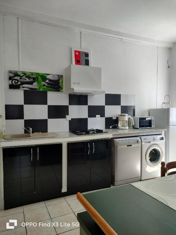 une cuisine avec un mur en damier noir et blanc dans l'établissement Appart la Percep, à La Tour-dʼAuvergne