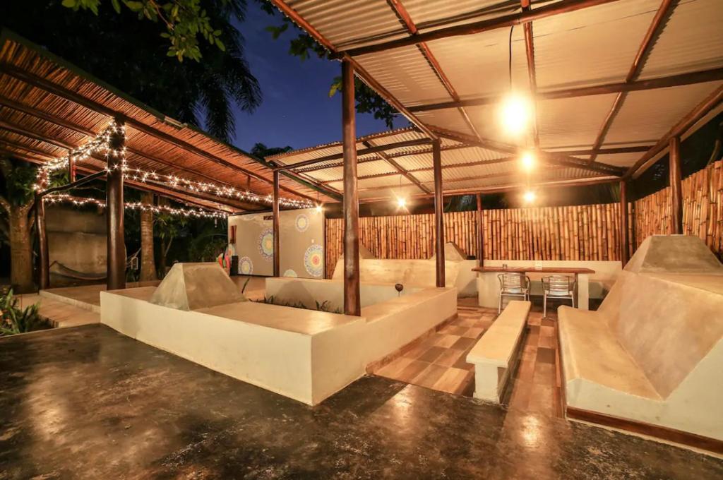 un pabellón con bancos, una mesa y luces en Pipe House Luxury Beach Glamping Retreat en Barco Quebrado