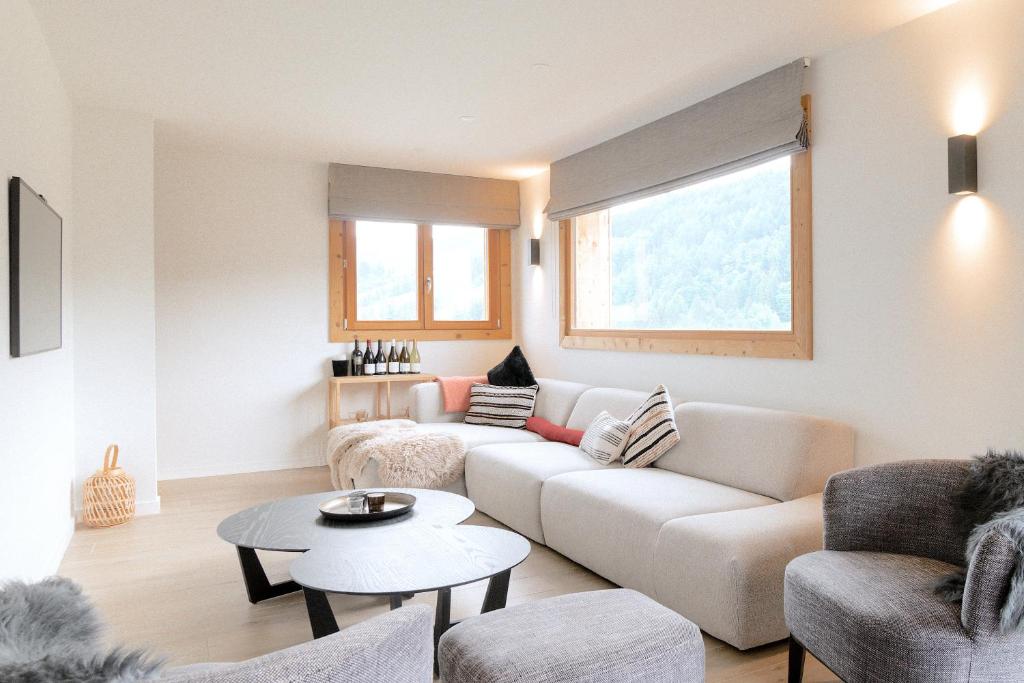een woonkamer met een bank en een tafel bij Bright & elegant stand alone chalet - 8 ppl - Vois Le Mont in Les Gets