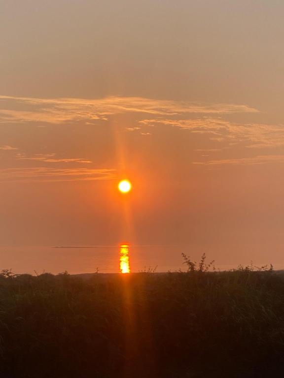 Sončni vzhod oz. zahod, fotografiran iz počitniške hiške oz. okolice