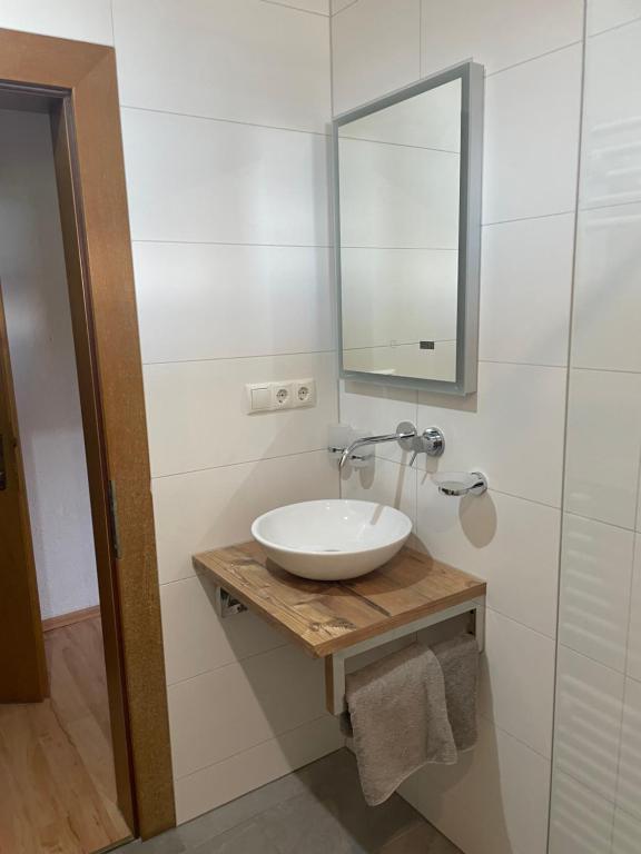 a white bathroom with a sink and a mirror at Landhaus Peer in Innsbruck