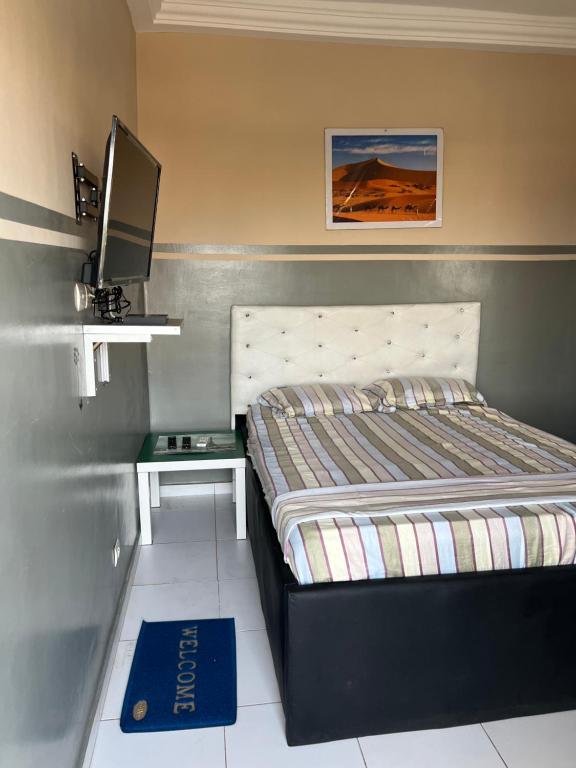 ein kleines Schlafzimmer mit einem Bett und einem TV in der Unterkunft Résidence Togoliving 