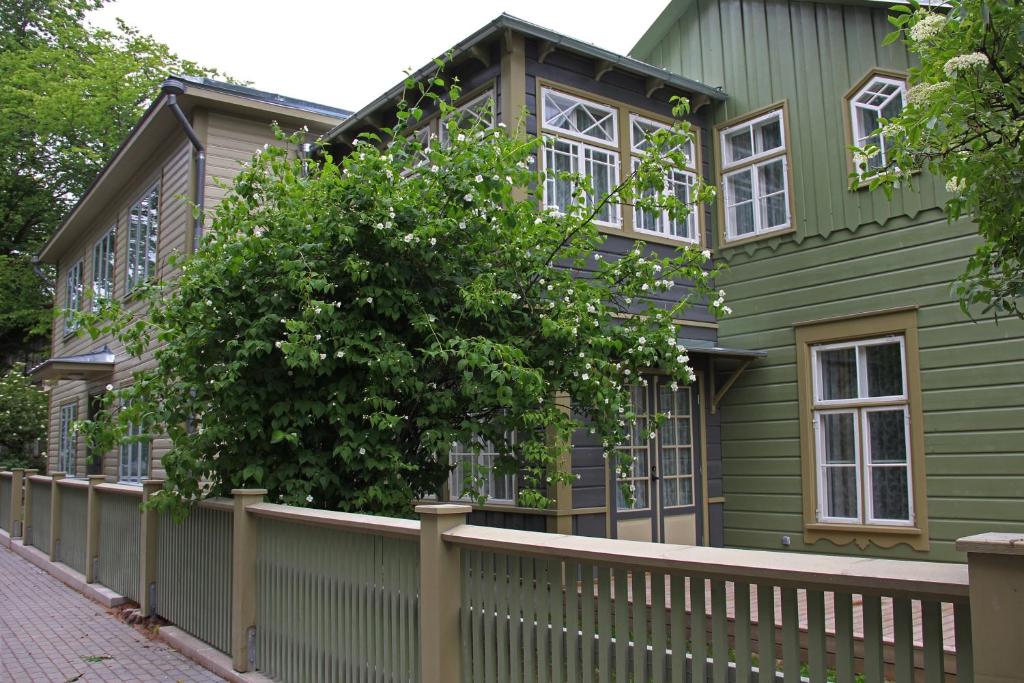 a green house with a fence at Pargimaja Apartments in Kuressaare