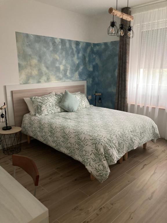 1 dormitorio con 1 cama y una pintura en la pared en L'angolo di Luna, en Gorizia