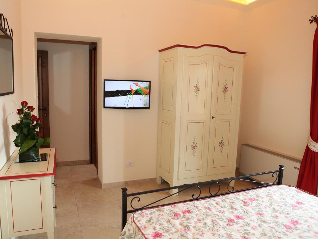 1 dormitorio con 1 cama y TV en la pared en Villa Alba en Marciana Marina