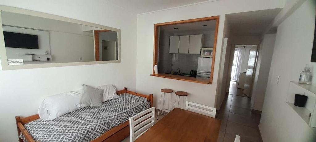 1 dormitorio con cama, mesa y espejo en Del sol mdp - departamento en Zona Aldrey en Mar del Plata