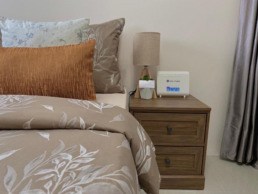 a bedroom with a bed and a night stand with a clock at Condo , WIFI up to 100mbps , Infinity Pool in Cebu City