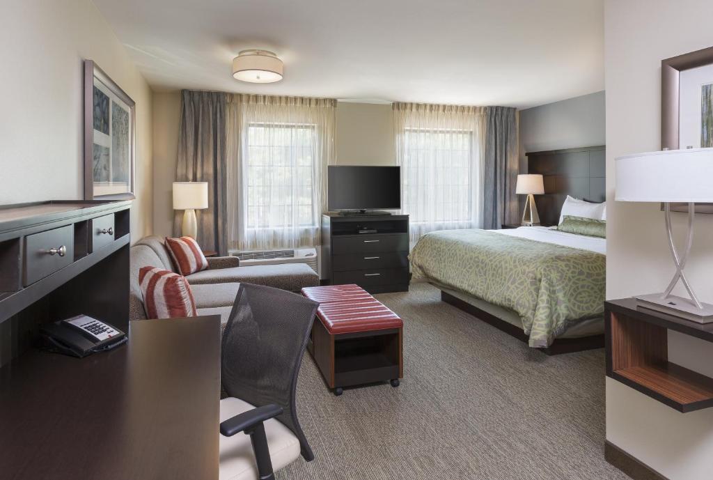 um quarto de hotel com um quarto e uma cama e um sofá em Staybridge Suites Canton, an IHG Hotel em North Canton