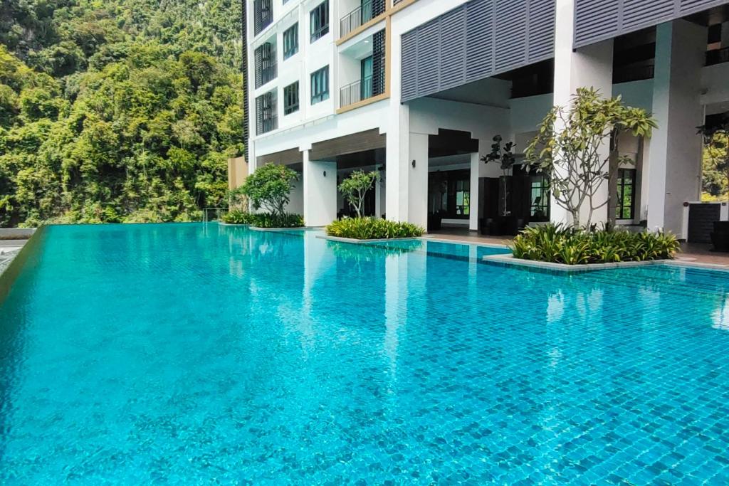 a swimming pool in front of a building at Sunway Onsen Suites - Theme Park Tambun Ipoh by Ryokan Management in Tambun