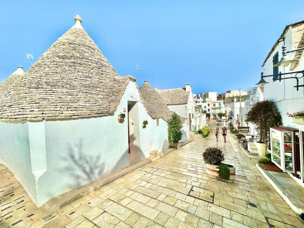 a building with a roof on a cobblestone street at Trulli Moon in Alberobello