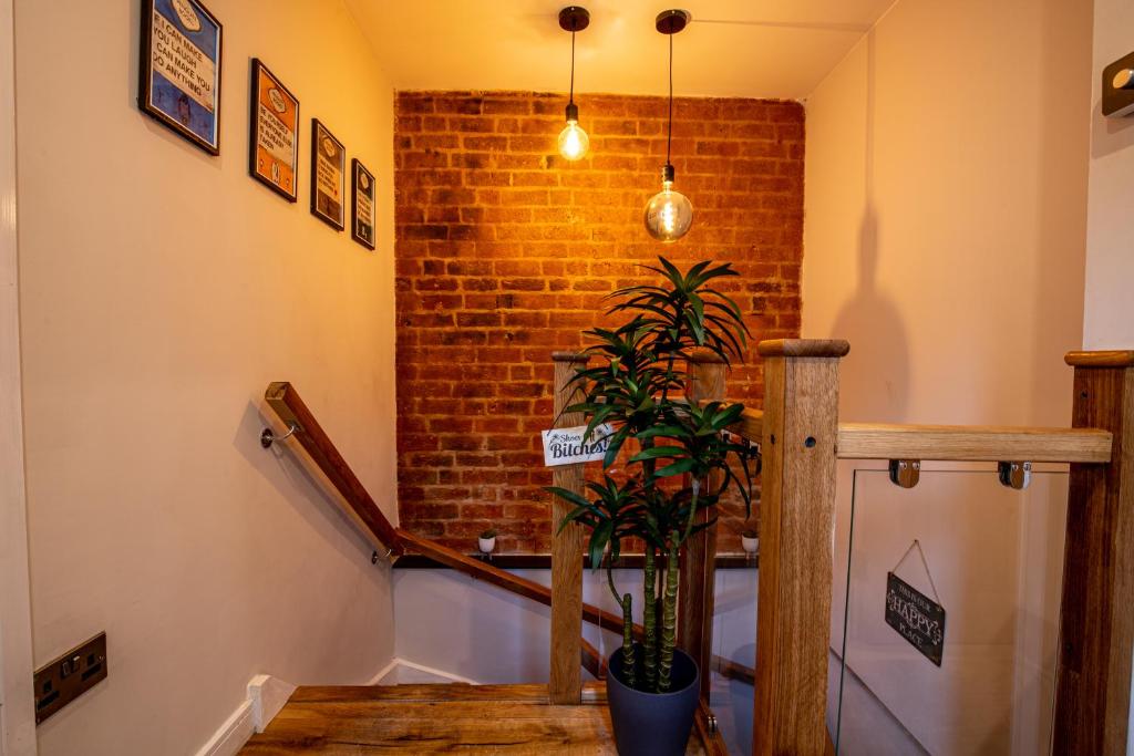 a staircase with a brick wall and a potted plant at VIP - 2 BR Grade 2 Luxury Industrial House with Log Burning FIRE & electric blinds in the Heart of the JQ in Birmingham