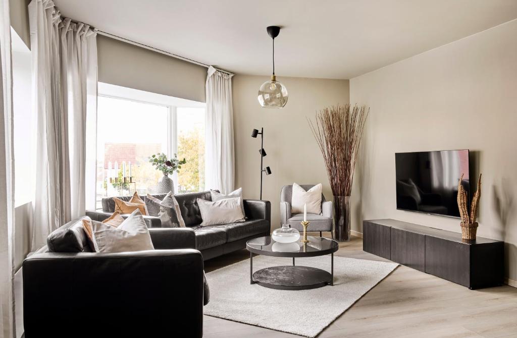 a living room with a couch and a tv at Krüger's Crib By Staysville in Stavanger