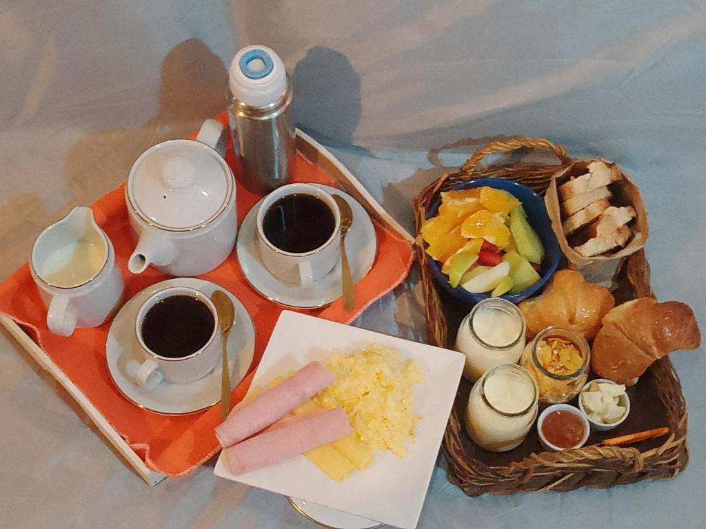 a table with a tray of food and two cups of coffee at AeroSuites in Las Heras