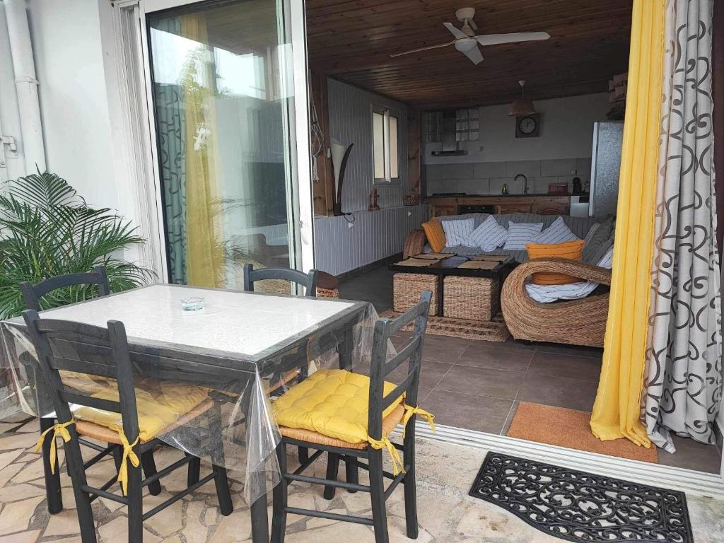 einen Tisch und Stühle auf einem Balkon mit einem Schlafzimmer in der Unterkunft Le Latanier in Petite Île