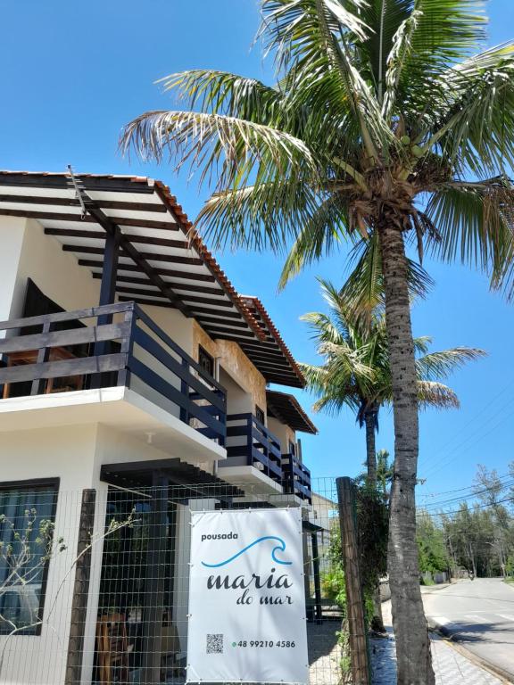 een gebouw met een bord voor een palmboom bij Pousada Maria do Mar in Garopaba