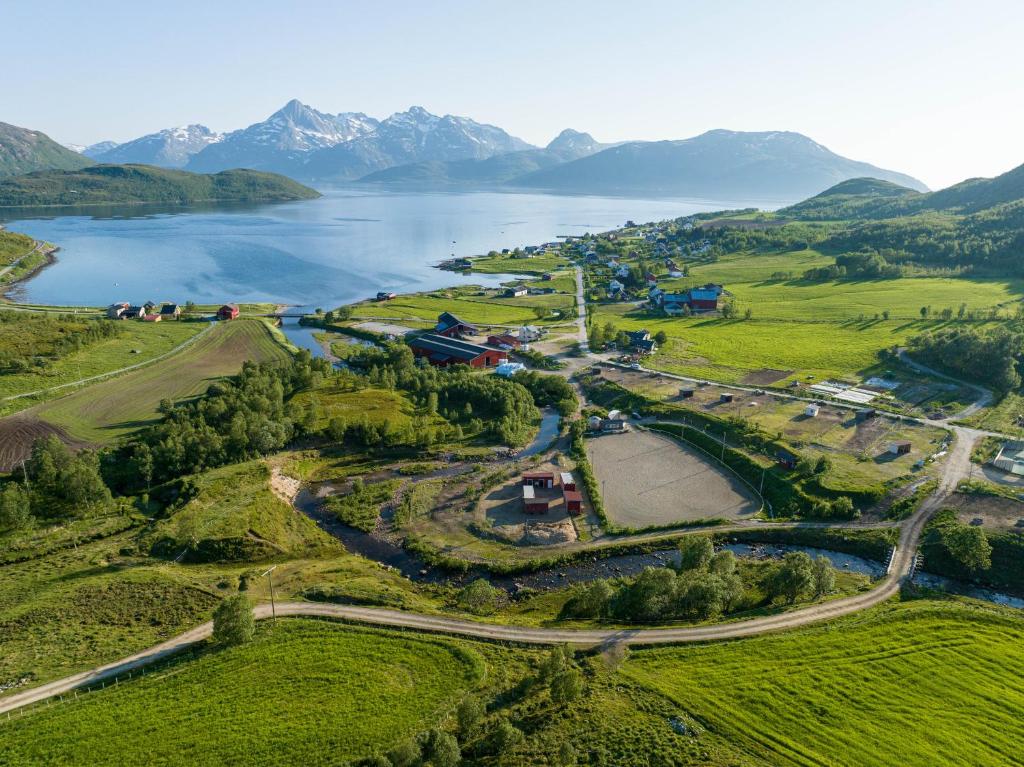 an aerial view of a lake with mountains in the background at Storjord Farmstay Ranchhouse in Kvaløya