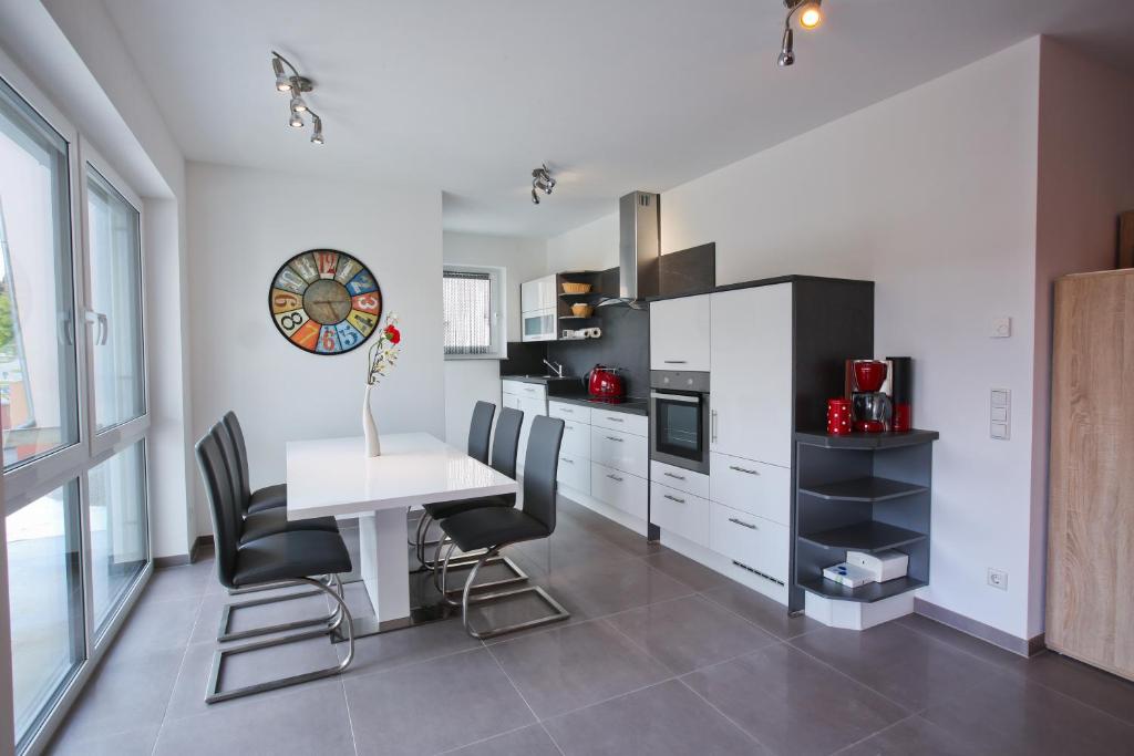 a kitchen with a white table and black chairs at Moderne 3-Zimmerwohnung Rottweil Zentrum in Rottweil