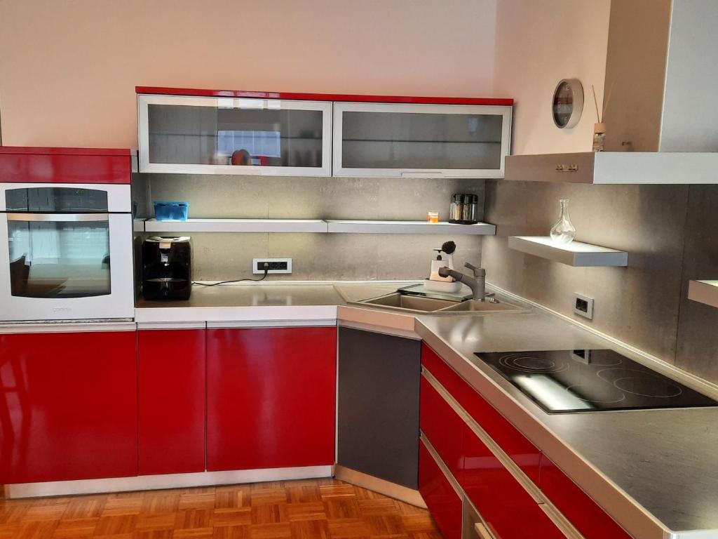 a kitchen with red cabinets and a sink at Apartma Mali grad in Kamnik