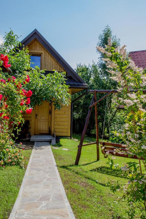 a garden with a wooden house and a pathway at Domek góralski u Felusia in Szczawnica