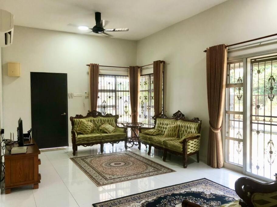 a living room with two chairs and windows at Zara Dija Homestay Klia/Klia2 in Sepang