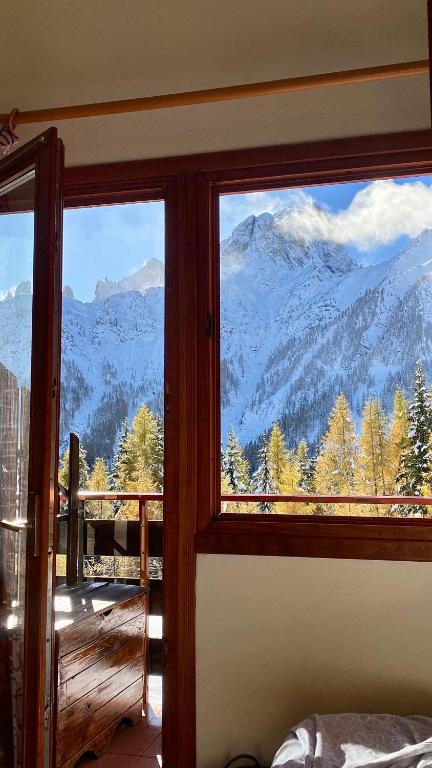 a room with a window with a view of mountains at IL COVO DELLO SCIATORE in Falcade