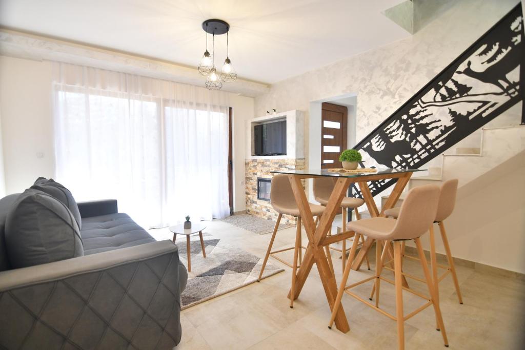 茲拉蒂博爾的住宿－Brvnara Mont 2，客厅配有桌子和沙发