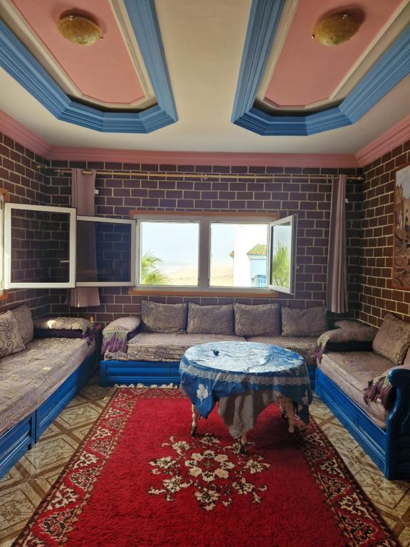 - un salon avec un canapé et une table dans l'établissement Maison bord de mer, à Zaouia Sidi Ouaggag