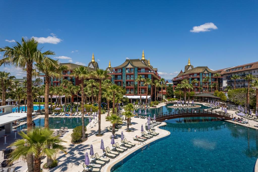 貝萊克的住宿－暹羅典雅Spa酒店，一个带椅子和棕榈树的度假游泳池