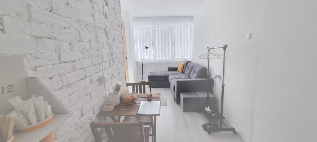 a living room with a couch and a brick wall at Apartment in Vitina