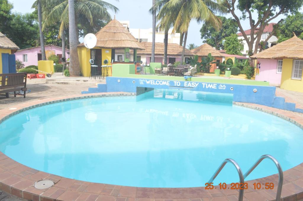 a large blue swimming pool in a resort at Easy Time Lodge in Kololi