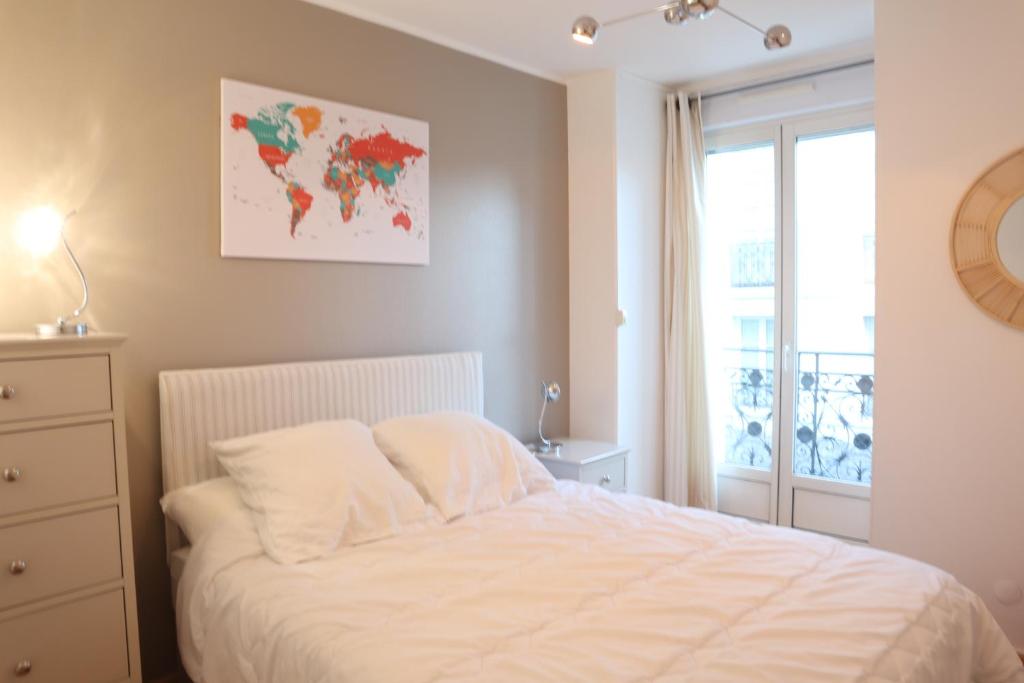 a bedroom with a white bed and a window at Résidence Poste & Golf, appartement pour 4 personnes au cœur de Luchon in Luchon