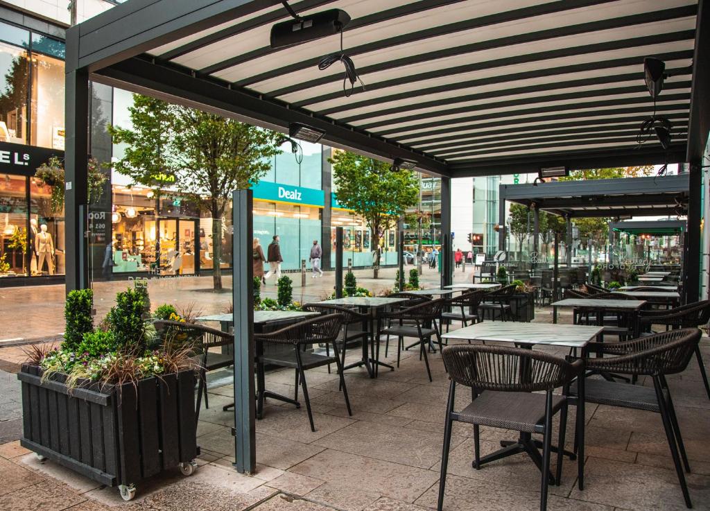 リムリックにあるThe Bedford Townhouseの通りの前にある空きレストランで、テーブルと椅子が備わります。