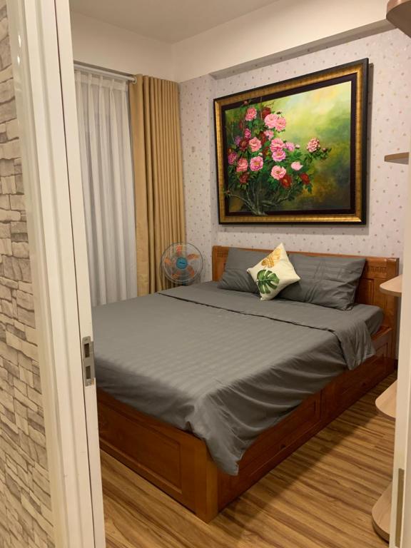 a bedroom with a bed with a painting on the wall at Homestay 9view thủ Đức in Ho Chi Minh City