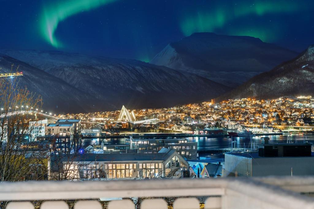 z powietrza widok na miasto w nocy z zorzą polarną w obiekcie Arctic Homes - Majestic View w mieście Tromsø