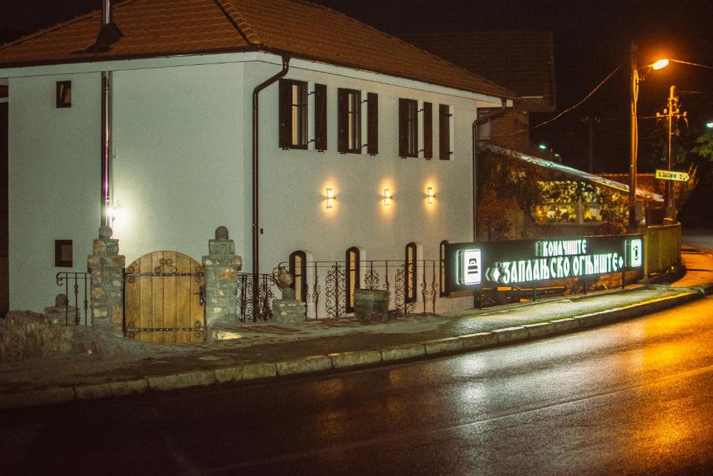 a building with a sign on the side of a street at Konačište Zaplanjsko ognjište 