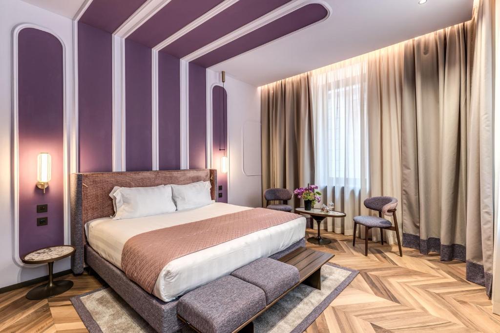 a bedroom with purple walls and a bed and a table at Eitch Belsiana Relais in Rome