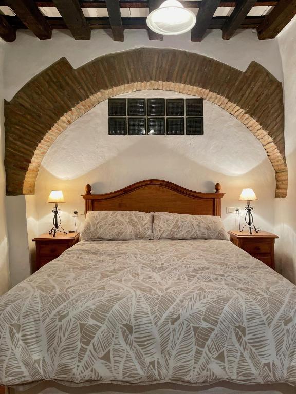 sypialnia z dużym łóżkiem i 2 lampami w obiekcie Casa Rural El Zaguán w mieście Jimena de la Frontera