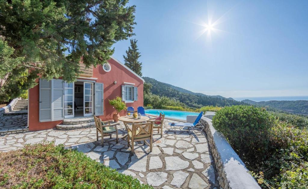 a patio with a table and chairs in front of a house at Agios Nikitas Villas in Agios Nikitas