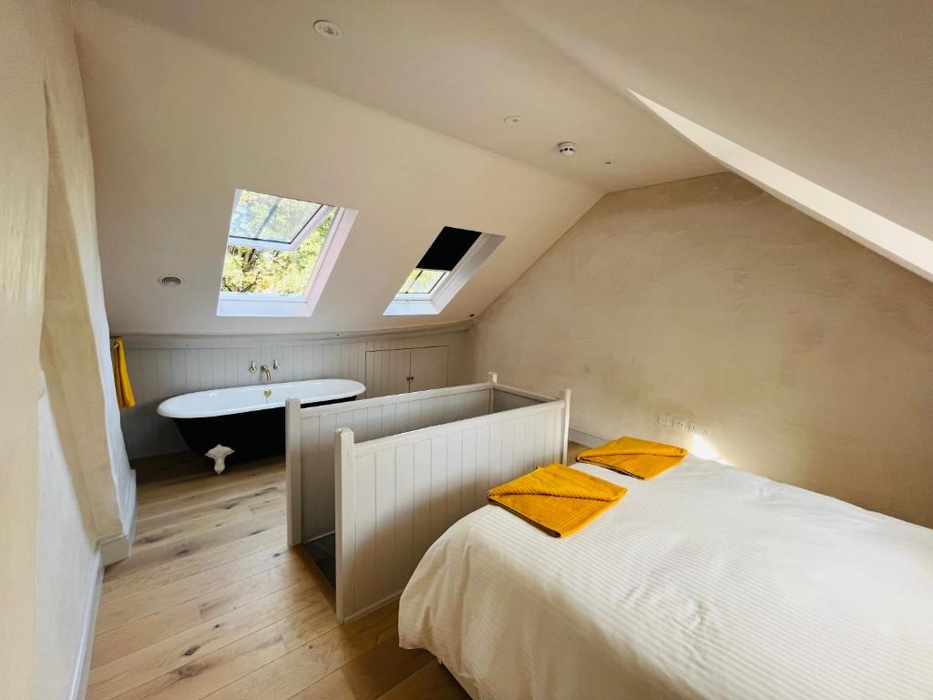 um quarto no sótão com uma cama e uma banheira em Henley Bolt Hole em Henley on Thames