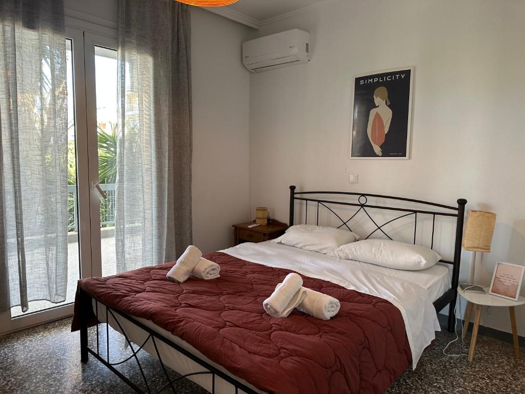 een slaapkamer met een groot bed en handdoeken bij Wait 'n Sea Apartment by A&D Properties in Porto Rafti