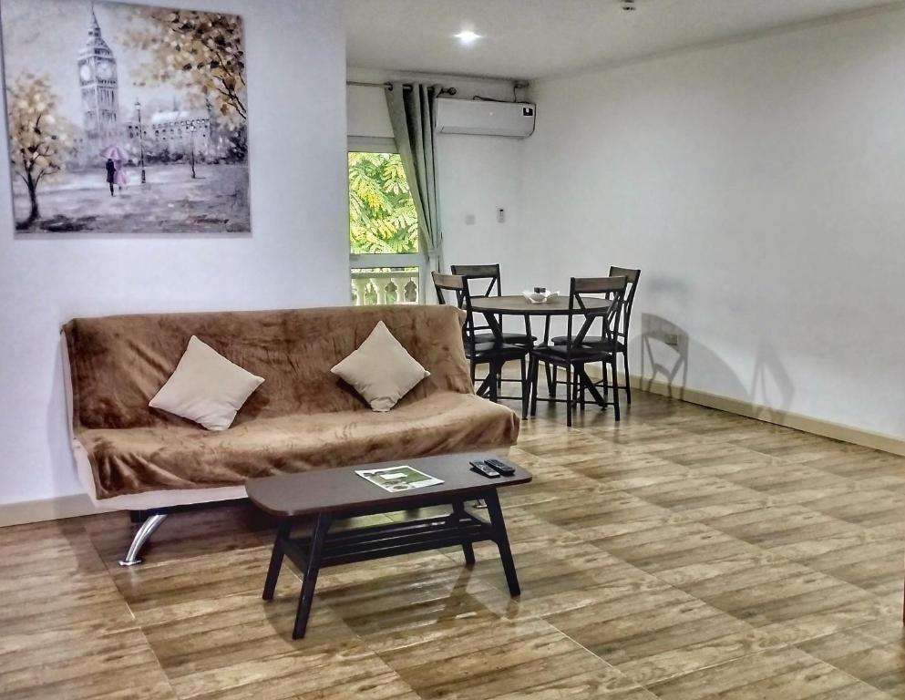 ein Wohnzimmer mit einem Sofa und einem Tisch in der Unterkunft Dovass Self Catering Apartments in Takamaka
