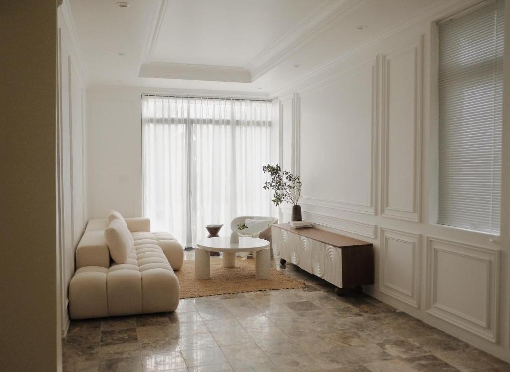 a white living room with a couch and a table at BeLam in Hue Villa in Hue