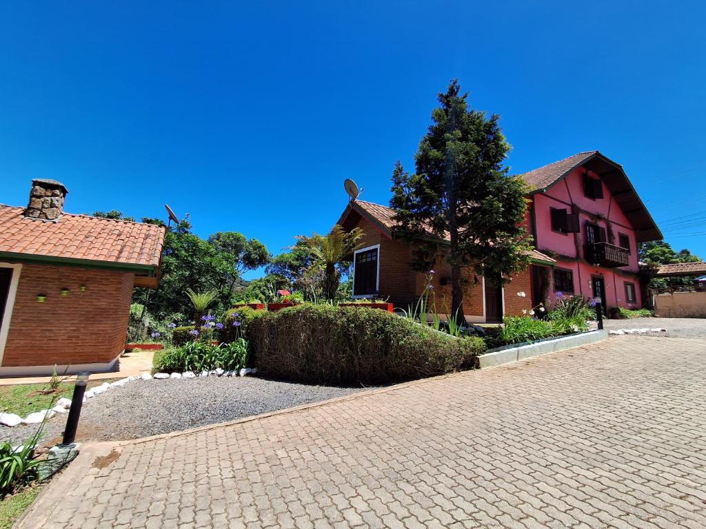 a brick driveway in front of a house at Pousada Encanto da Serra in Monte Verde