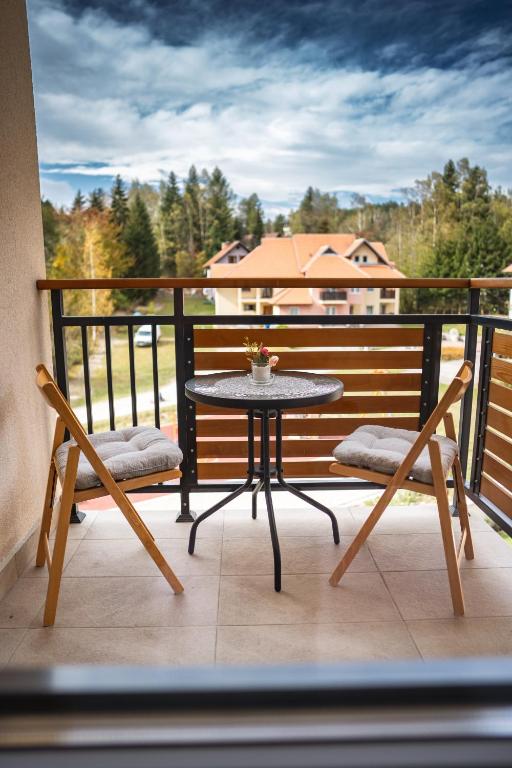 a patio table and two chairs on a balcony at Apartman Georgijev with private Free parking in Zlatibor