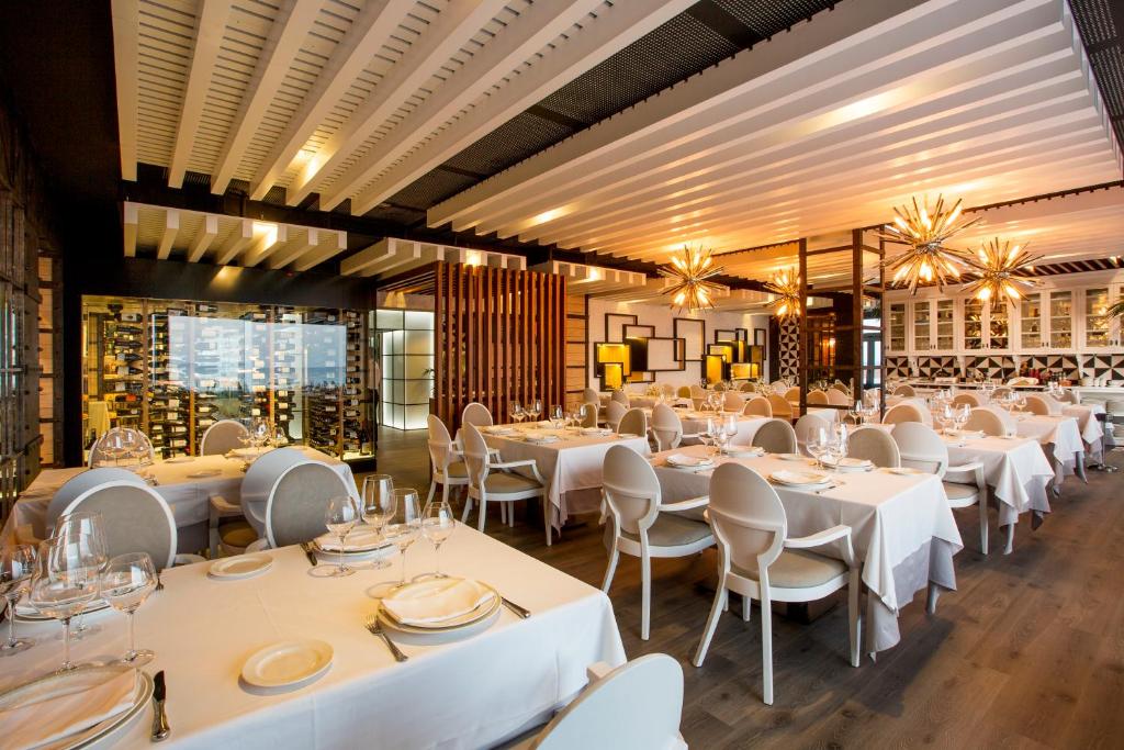 a dining room with white tables and chairs at Hotel Antonio in Zahara de los Atunes