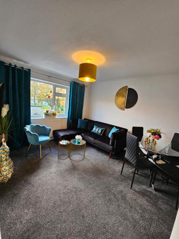 een woonkamer met een bank, stoelen en een tafel bij Large Stylish 2 Bedroom Apartment Stevenage Sleep 6 in Stevenage