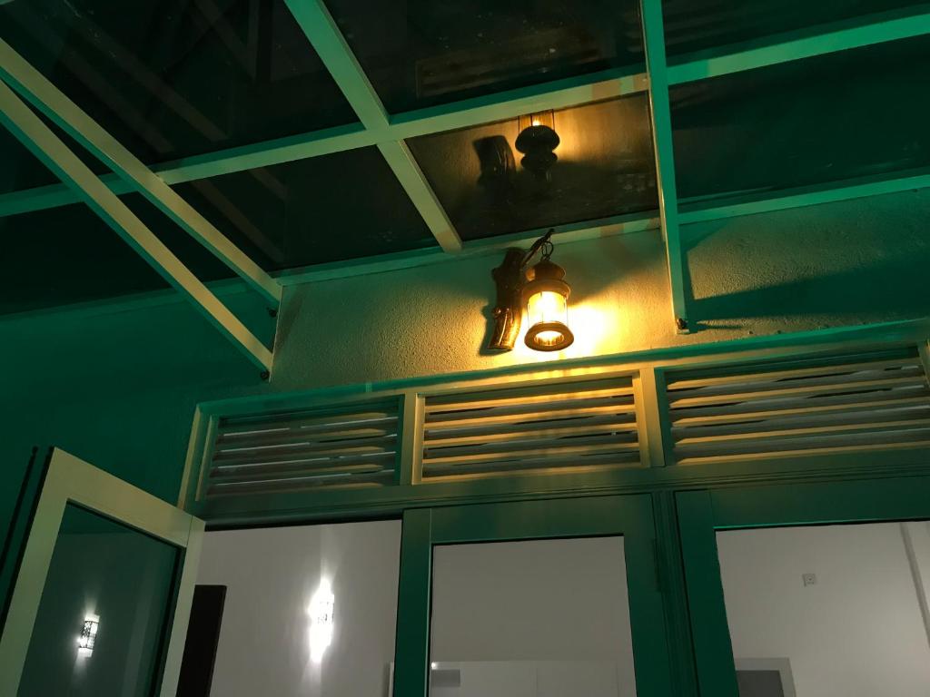 a room with a green ceiling with a light on it at White Rooms by Sineth in Ratmalana