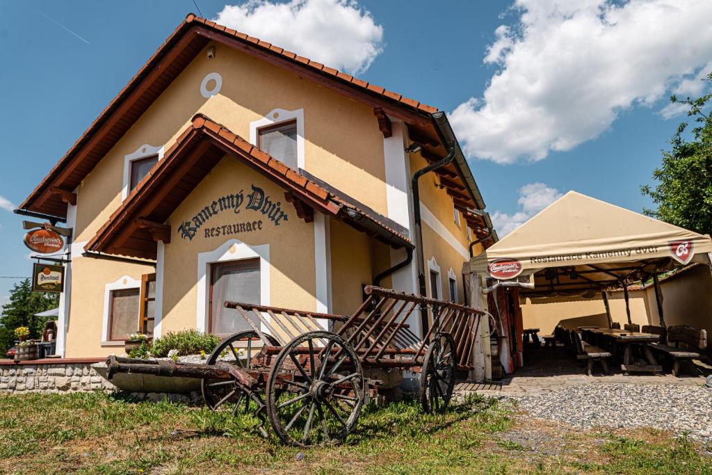 a building with a cart in front of it at Pension Kamenný Dvůr in Františkovy Lázně