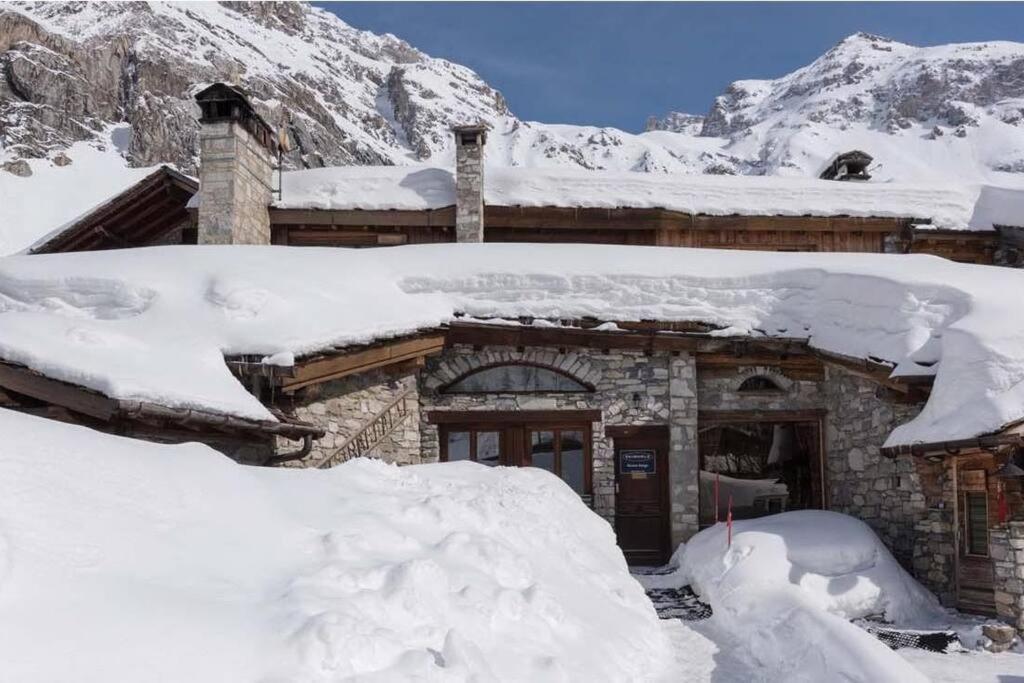 a house covered in snow in front of a mountain at BONNE NEIGE in La Daille