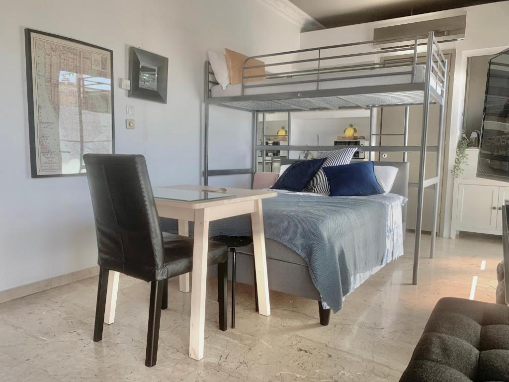 a bedroom with a bed and a table and a bunk bed at Perfect location for the Olympic stadium Would sleep 4 comfortably for an overnight stay in Athens